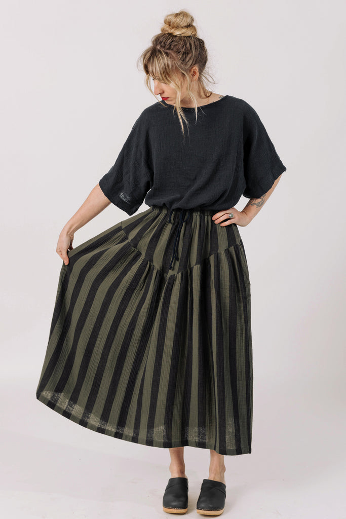 Front view of model wearing Ayana Top in Black and Jessie Stripe Skirt in Mud in front of white background