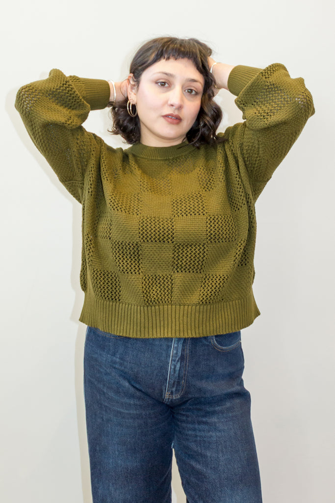 Anya Checkerboard Sweater in Fennel paired with denim jeans on model in front of white background