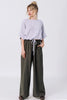 Front view of model wearing Ayana Top in Mist and Atlas Pant in Mud, standing with hands in pants pockets in front of white background