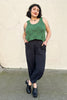 Model wearing Zoe Top in Fern and Cadence Pant in Faded Black/Black Stripe in front of white wall