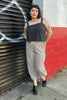 Model wearing Bianca Top in Black and Cadence Pant in Oat/Black Stripe in front of white and red painted wall