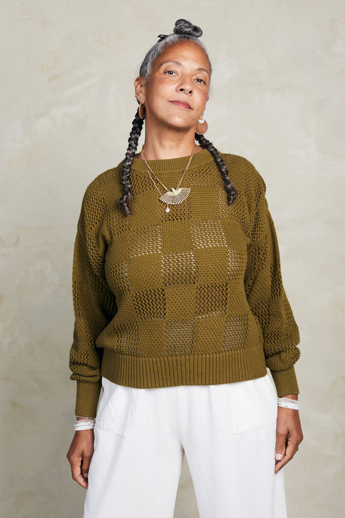 Anya Checkerboard Sweater in Fennel paired with Cadence Pants in White on model in front of white background