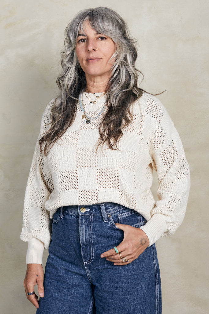 Model wearing Anya Checkerboard Sweater in Biscuit on white background