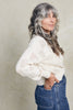 Side view of model wearing Anya Checkerboard Sweater in Biscuit on white background