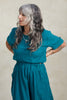 Noa Stripe Top in Ocean, paired with Fawn Stripe Skirt in Ocean, on model standing with hands on hips in front of white background