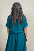 Back view of Noa Stripe Top in Ocean, paired with Fawn Stripe Skirt in Ocean, on model standing in front of white background.