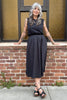 Model wearing Minnie Tank in Black and Fawn Poplin Skirt in Black in front of brick wall with amber windows