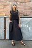 Model wearing Minnie Tank in Black and Fawn Poplin Skirt in Black in front of brick wall and metal storage lockers