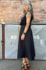 Side view of model wearing Minnie Tank in Black and Fawn Poplin Skirt in Black in front of brick wall and metal storage lockers