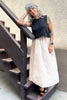 Model wearing Minnie Tank in Black and Fawn Poplin Skirt in Oat standing on wooden stairs