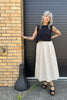 Model wearing Minnie Tank in Black and Fawn Poplin Skirt in Oat in front of brick wall with black garage door