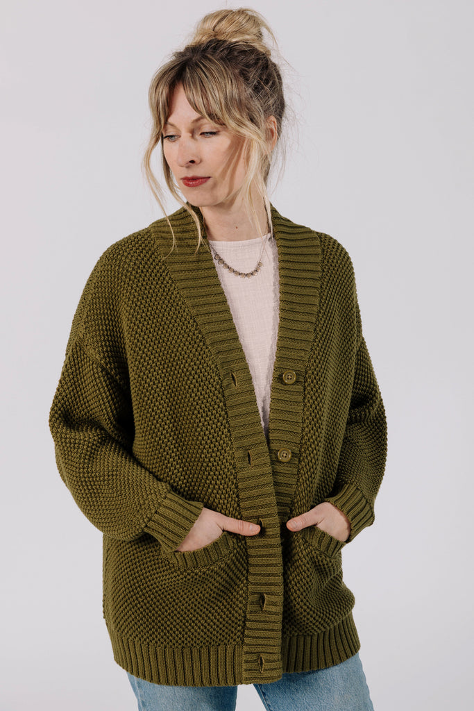 Front view of model wearing Frankie Cardigan in Fennel, Ayana Top in White, and light wash jeans, with hands in cardigan pockets in front of white background