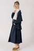 Side view of model wearing Lino Cardigan in Indigo, Ayana Top in Oyster, and Fawn Poplin Skirt in Indigo in front of white background
