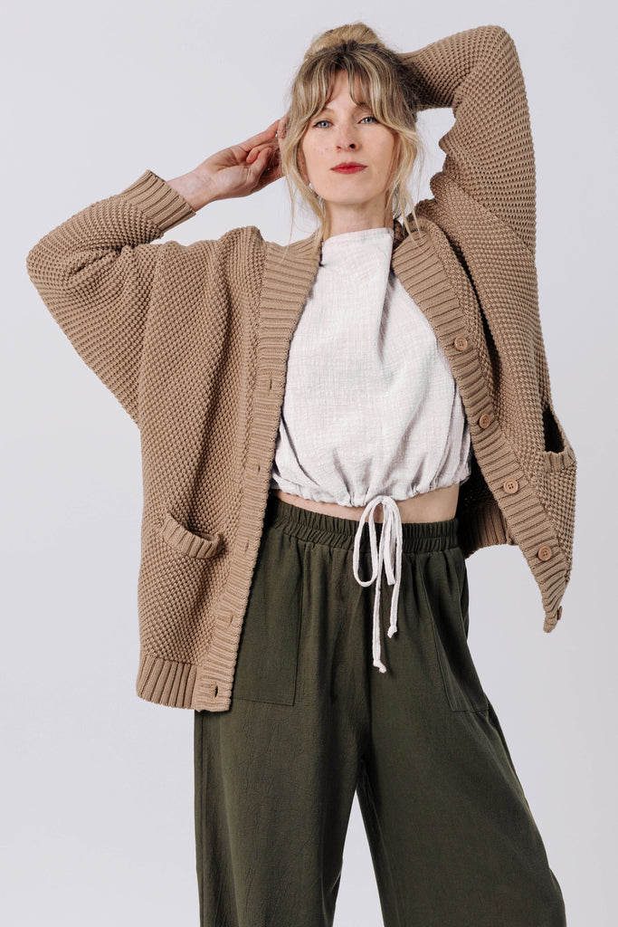 Front view of model wearing Frankie Cardigan in Tan , Ayana Top in White, and Atlas Pant in Mud in front of white background