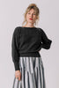 Front view of model wearing Ivy Sweater in Black and Jessie Stripe Skirt in Oyster, with one hand on hip, standing in front of white background