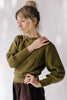 Model wearing Ivy Sweater in Fennel and Atlas Pant in Chocolate standing with one hand on hip and one on shoulder in front of white background