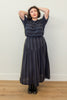 Model wearing Izzy Top and Jessie Skirt set in Faded Black Stripe standing with hands above their head, in front of white wall