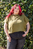 Model wearing Jones Top in Fennel and black jeans in front of vine-covered wall