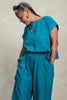 Model wearing Jones Top in Ocean and Larkin Pant in Ocean, standing with one hand in pocket, in front of white background