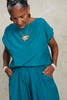Model wearing Jones Top in Ocean and Larkin Pant in Ocean, standing with hands in pockets, in front of white background