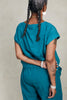 Back view of model wearing Jones Top in Ocean and Larkin Pant in Ocean, standing with arms behind back, in front of white background