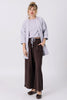 Front view of model wearing Jules Cardigan in Mist, Ayana Top in Mist, and Atlas Pant in Chocolate, standing  in front of white wall