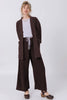 Front view of model wearing Jules Cardigan in Chocolate, Ayana Top in Mist, and Atlas Pant in Chocolate, standing  in front of white wall