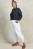 Lana Sweater in Charcoal and Cadence Pant in White on model standing with hands in pockets, in front of white background