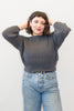 Model wearing Lana Sweater in Charcoal and light wash jeans, standing in front of white background
