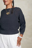 Close up of Lana Sweater in Charcoal and Cadence Pant in White on model standing in front of white background