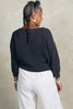 Back view of Lana Sweater in Charcoal and Cadence Pant in White on model standing in front of white background