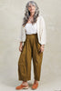 Model wearing Maeva Sweater in Biscuit and Larkin Pant in Fennel in front of white background