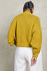 Back view of model wearing Lino Cardigan in Chartreuse and Cadence Pant in White  in front of white background