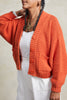 Close up of model wearing Lino Cardigan in Tomato in front of white background