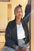 Maeva Cardigan in Charcoal on model with arm raised against a doorway