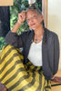 Maeva Cardigan in Charcoal paired with Jessie Skirt in Dijon on sitting model