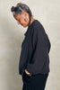 Side view of Maeva Cardigan in Charcoal on model in front of white background