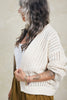 Side view of Maeva Cardigan in Biscuit on model in front of white background