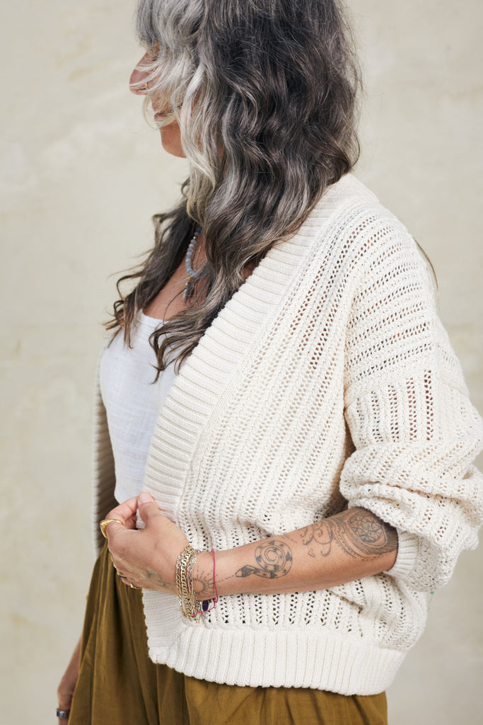 Side view of Maeva Cardigan in Biscuit on model in front of white background