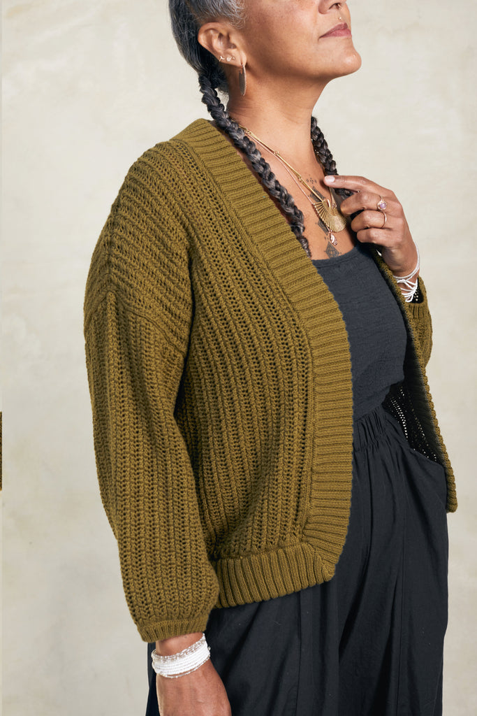 Side view of model wearing Maeva Cardigan in Fennel in front of white background