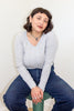 Maisie Long Sleeve Top in Oyster paired with denim jeans on model sitting in front of white wall