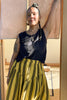 Front view of Minnie Tank in Black paired with Jessie Stripe Skirt in Dijon on model leaning against doorway
