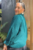 Back side of Oona Cardigan in Ocean on model in front of grey building
