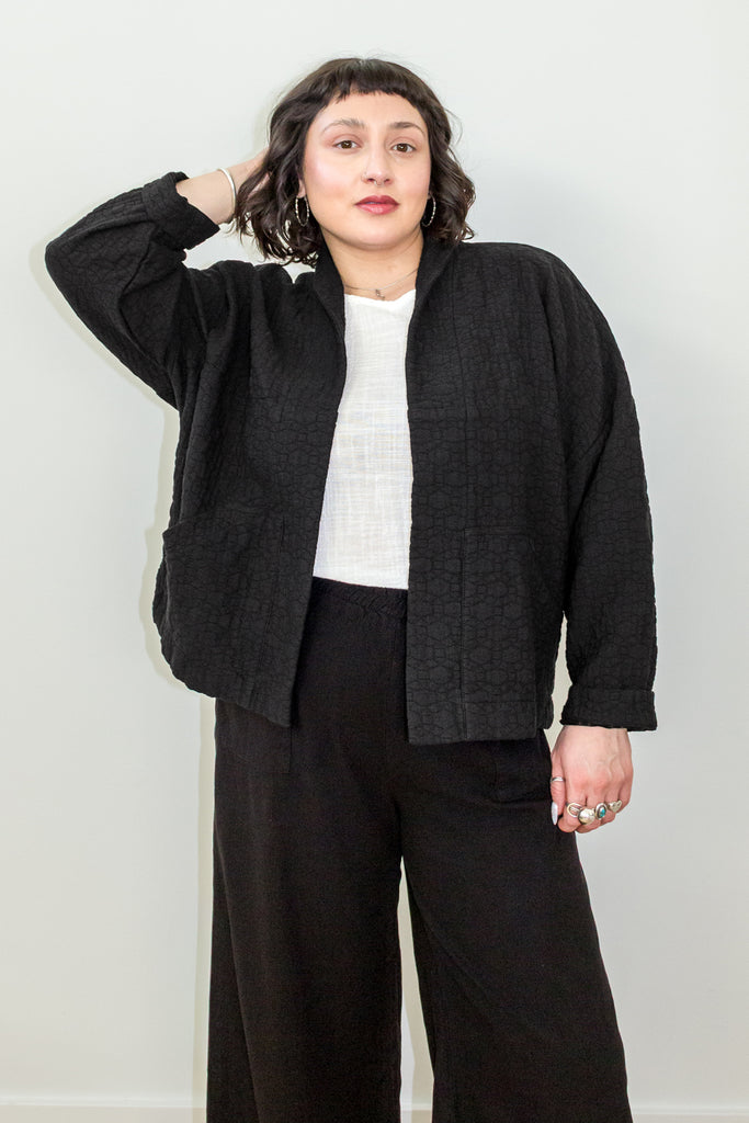 Front view of model wearing Oona Cardigan in Black, Ayana Top in White, and Atlas Pant in Black in front of white background