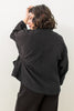 Back view of model wearing Oona Cardigan in Black in front of white background