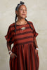 Perry Stripe Dress in Brick on model with hands in pockets in front of white background