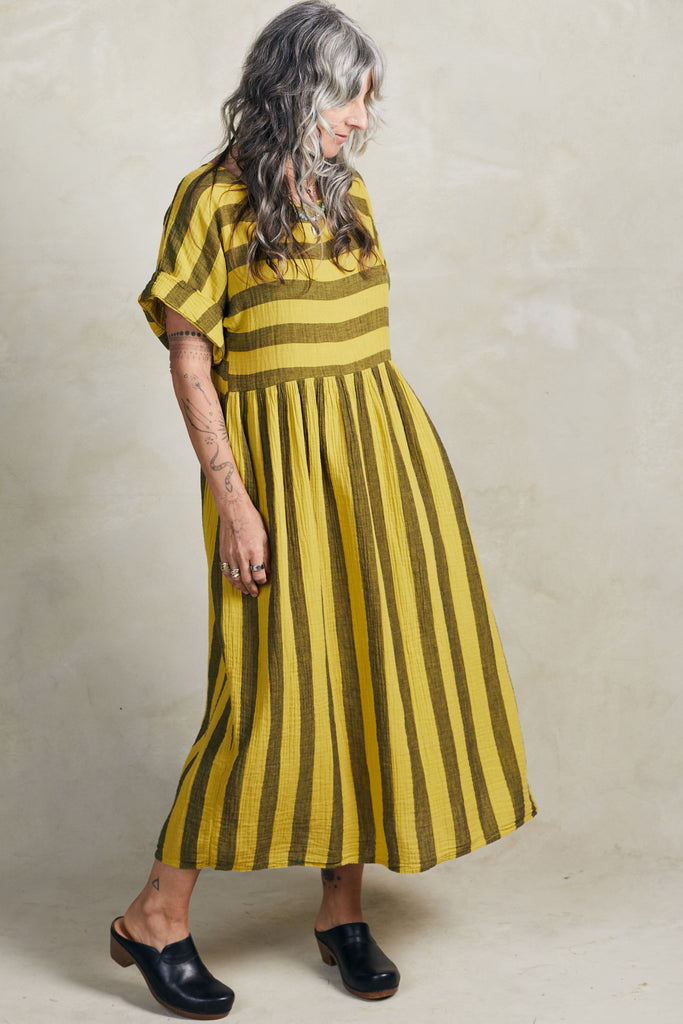Model wearing Perry Stripe Dress in Dijon, in front of white background