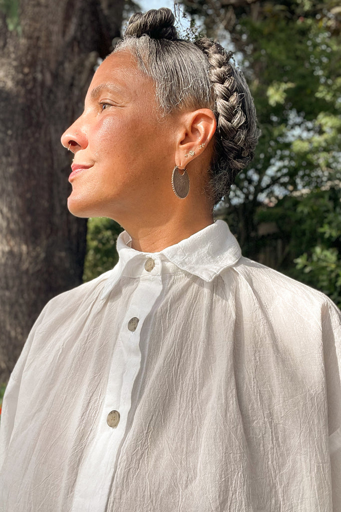 Close up view of model in Cropped Poet Blouse in White, with tree in the background