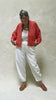 Video of model wearing Lino Cardigan in Tomato and Cadence Pant in White, slowly turning around in front of white background