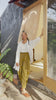 Video of model wearing Long Poet Blouse in White, Minnie Tank in White, and Cadence Pants in Dijon. Video shows model buttoning up shirt, cuffing sleeves, and putting hands in pants pockets.